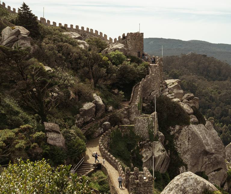 Stone walls and steps of the Castle of the Moors winding across the forested hills above Sintra.